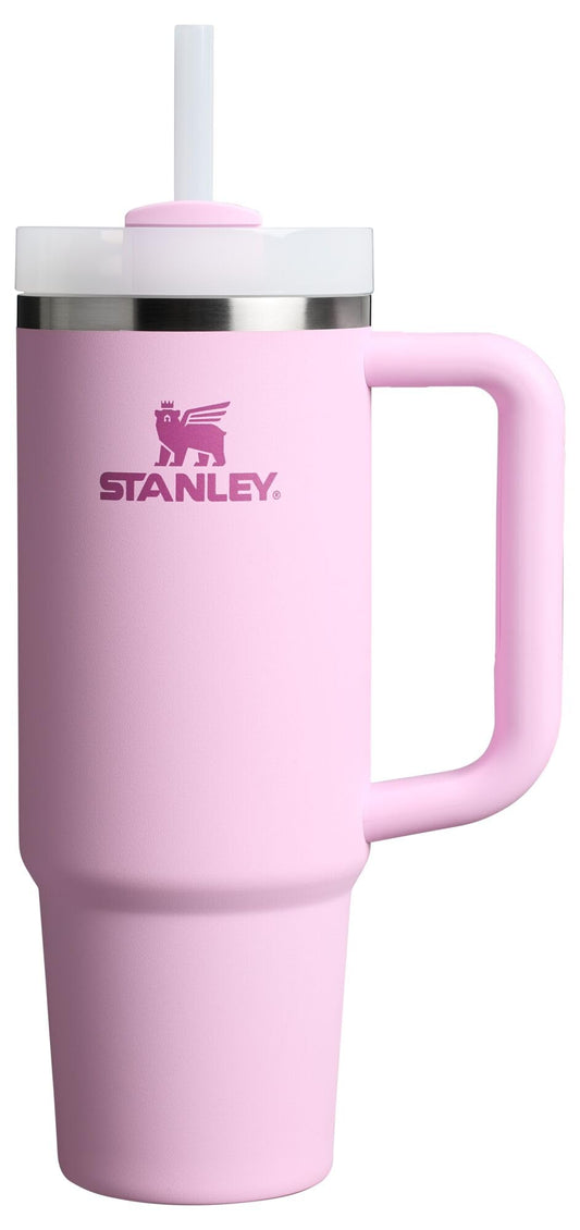 Pink Stanley tumbler with a handle on a white background